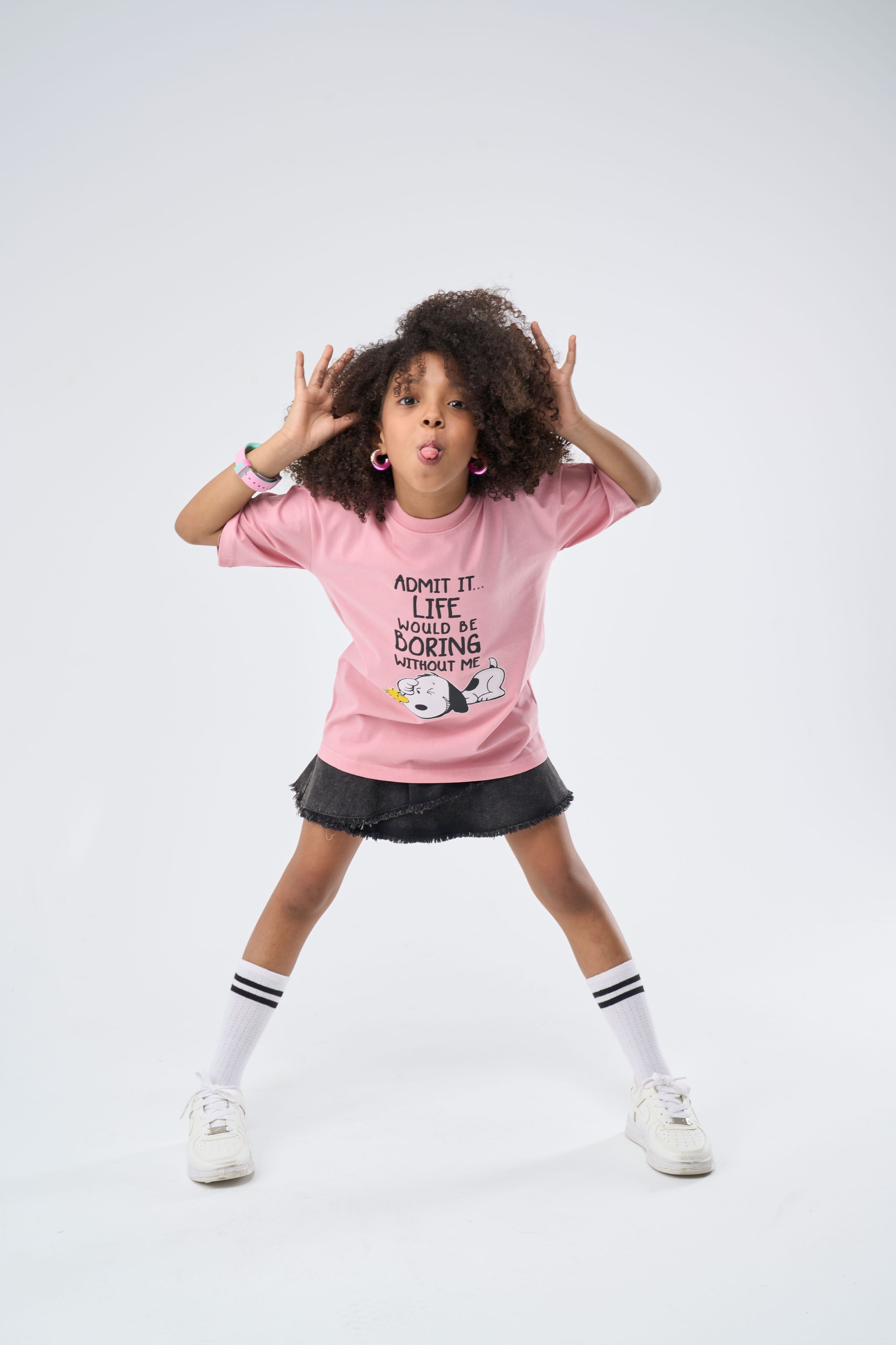 Girl wearing a Pink oversized t-shirt with printed text and graphics
