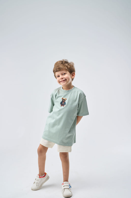 Child wearing a Mint Green Oversized T-Shirt with a printed small bear graphic 