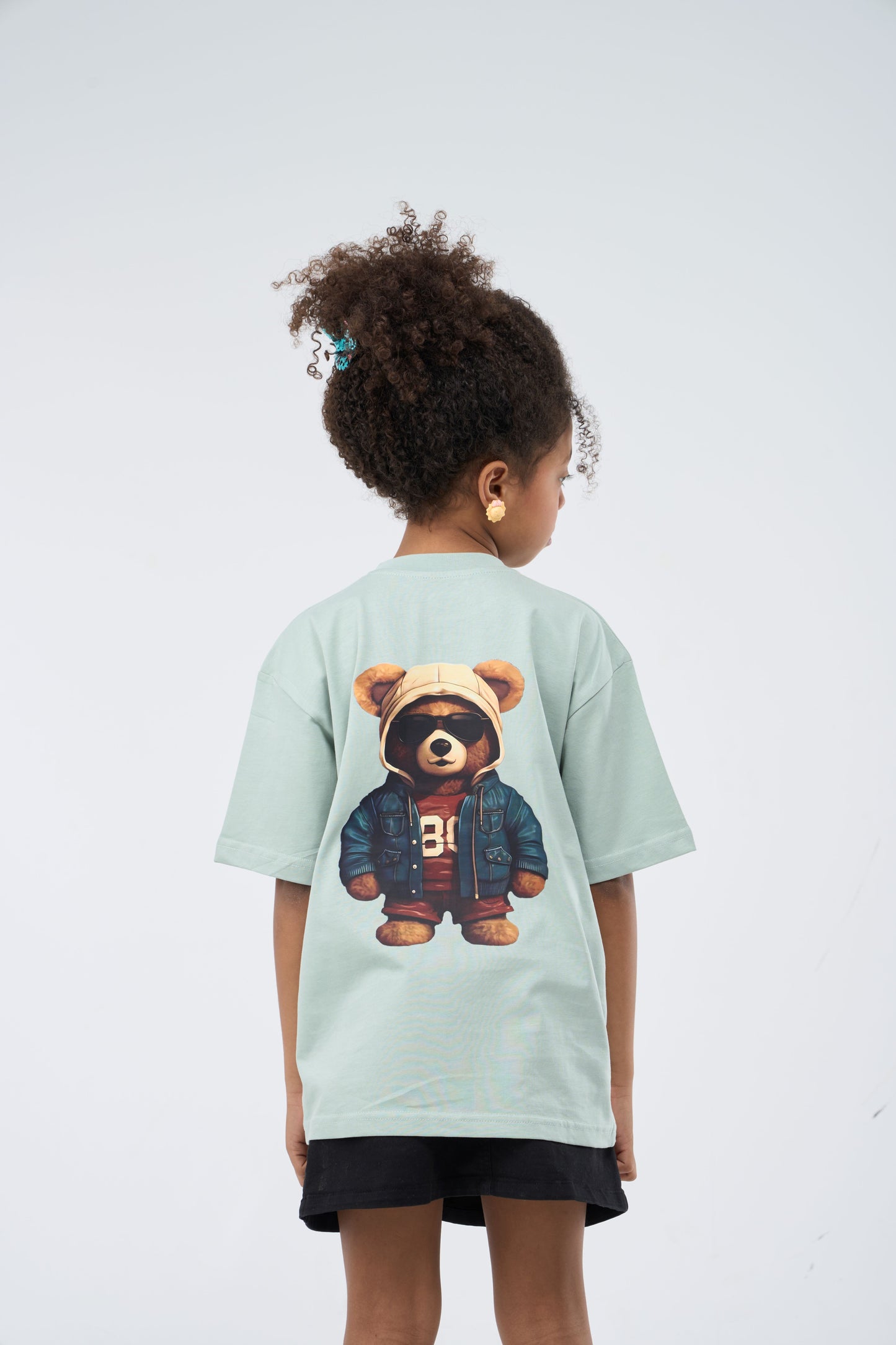 Child wearing a Mint Green Oversized T-Shirt with a bear graphic printed on the back 