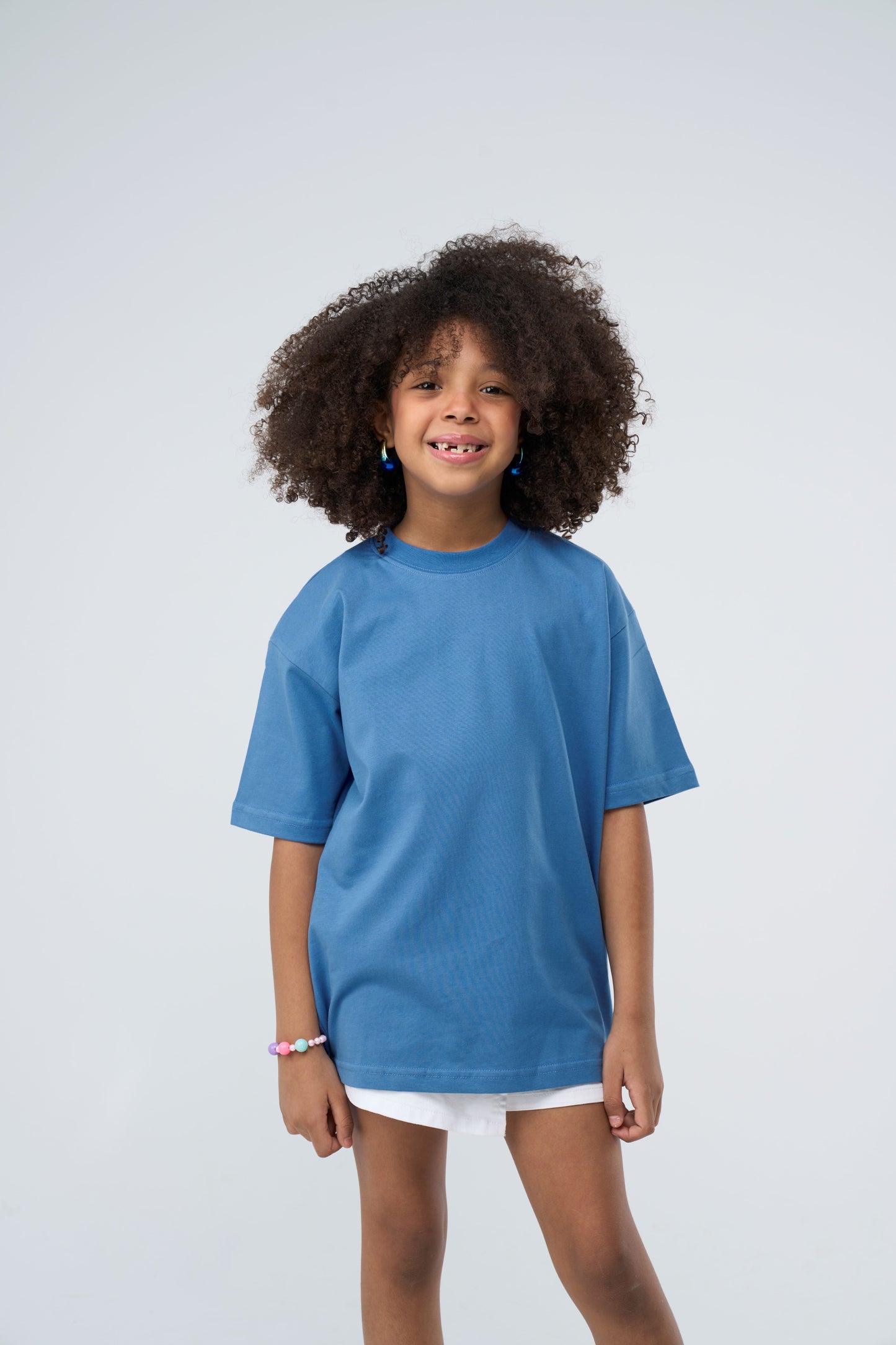 Child wearing a sky blue oversized t-shirt