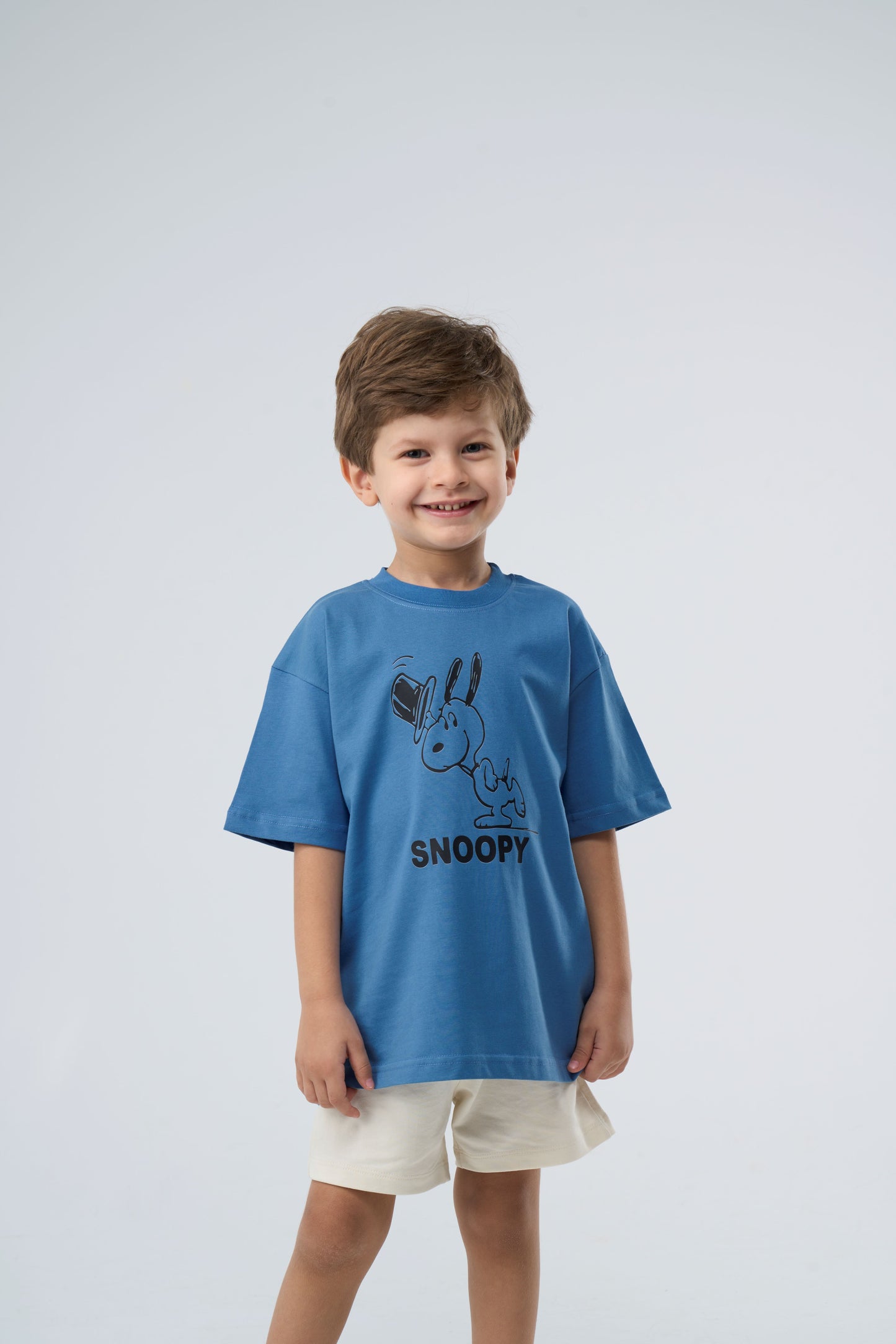 Young boy wearing a blue t-shirt with a Snoopy graphic 