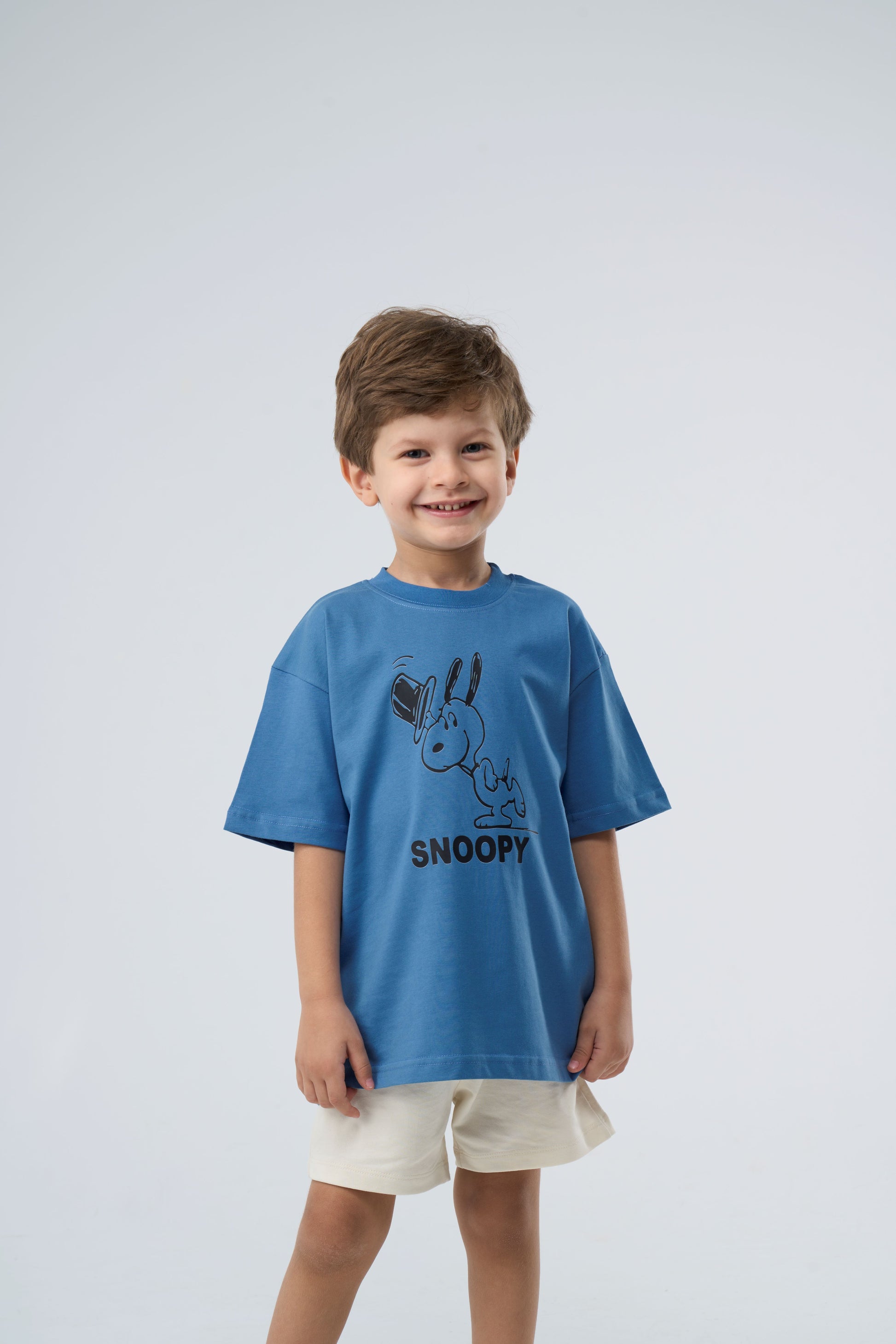 Young boy wearing a blue t-shirt with a Snoopy graphic 
